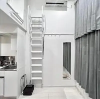 a white staircase in a room with a kitchen at Shinjuku sumika5 in Tokyo