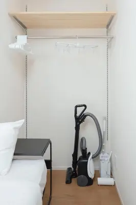 a room with a blow dryer next to a bed at Shimoshinmei Apartment 301 by Tranova in Tokyo