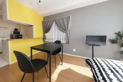 a bedroom with a table and two chairs and a television at Shimoshinmei Apartment 301 by Tranova in Tokyo