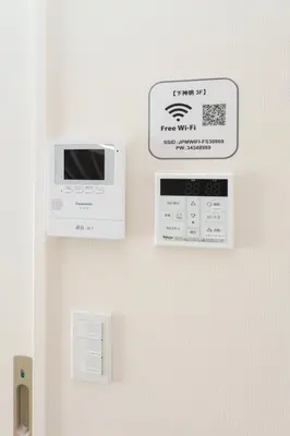a wall with a microwave and a sign on a wall at Shimoshinmei Apartment 301 by Tranova in Tokyo