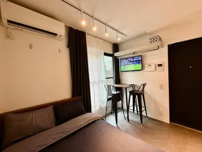 a bedroom with a bed and a table and a tv at Proto Shibuya Shinsen Style in Tokyo