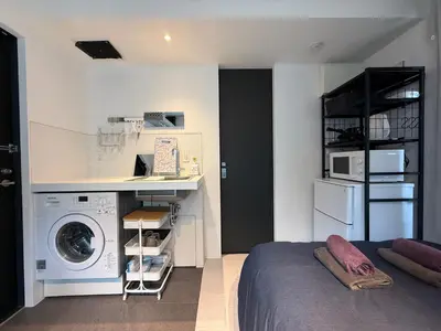 a bedroom with a washer and a washing machine at Proto Shibuya Shinsen Style in Tokyo