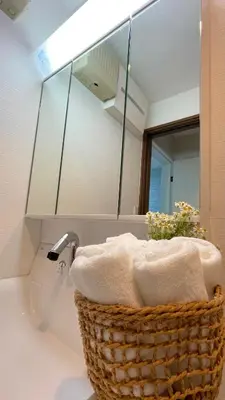 a bathroom with a basket on a sink with a mirror at Sunlit Retreat Home-2 min from Shinjuku Station in Tokyo