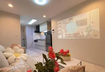 a living room with a couch and a kitchen at Sunlit Retreat Home-2 min from Shinjuku Station in Tokyo
