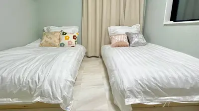 a bedroom with two beds with white sheets and pillows at Sunlit Retreat Home-2 min from Shinjuku Station in Tokyo
