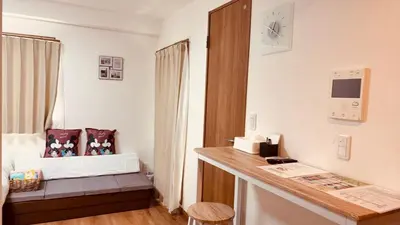 a room with a bed and a desk with a clock at \u30b9\u30ab\u30a4\u30c4\u30ea\u30fc\u306e\u5bbf 502 in Tokyo