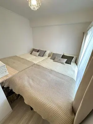 a bedroom with two beds and a chandelier at \u611b\u306e\u5c4b\u30db\u30c6\u30eb\u767e\u4eba\u753a in Tokyo