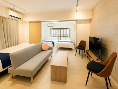 a room with two beds and a couch and a tv at Asakusa-Akihabara-Family-Friendly Stay- 4min Walk to Oshiage Sta- Switch & Mobile Wi-Fi in Tokyo