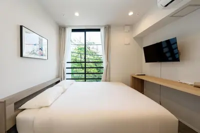 a bedroom with a large bed and a television at ZAITO Waseda Terra Hotel in Tokyo