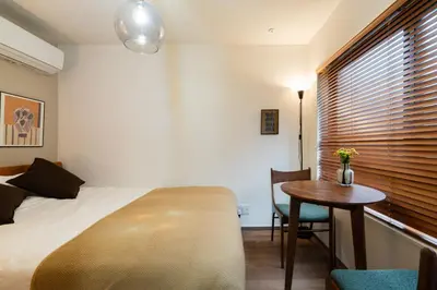 a bedroom with a bed and a table and a window at THE CAMINO Nakano 202 in Tokyo