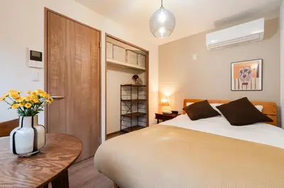 a bedroom with a bed and a vase of flowers on a table at THE CAMINO Nakano 202 in Tokyo