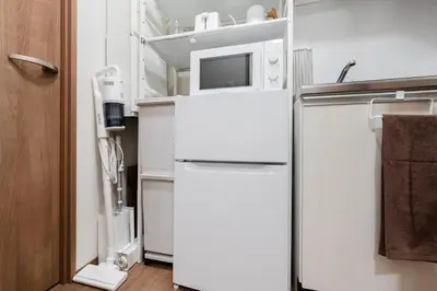a white refrigerator with a microwave on top of it at THE CAMINO Nakano 202 in Tokyo