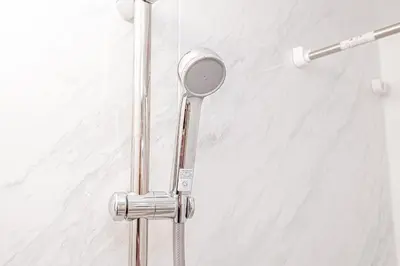 a shower with a shower head in a bathroom at Sheath Okachimachi Apartment Hotel in Tokyo