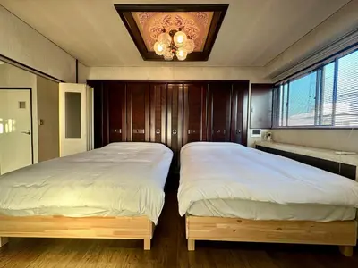 two twin beds in a bedroom with a ceiling at North Tokyo Grand Inn in Tokyo