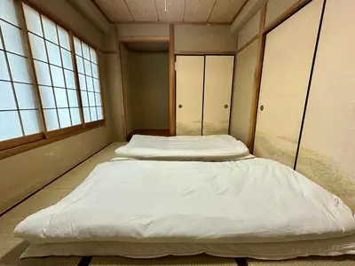 two beds in a room with two windows at North Tokyo Grand Inn in Tokyo