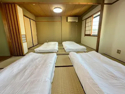 a room with three beds in it at North Tokyo Grand Inn in Tokyo