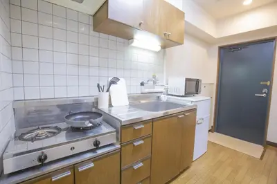 a kitchen with a stove and a sink in it at \u65b0\u5bbf\u76f4\u901a \u89b3\u5149 \u30b7\u30e7\u30c3\u30d4\u30f3\u30b0 \u30b0\u30eb\u30e1\u30b9\u30c6\u30a4 EoYg in Tokyo