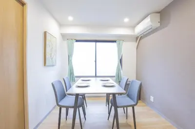 a dining room with a table and chairs and a window at \u65b0\u5bbf\u76f4\u901a \u89b3\u5149 \u30b7\u30e7\u30c3\u30d4\u30f3\u30b0 \u30b0\u30eb\u30e1\u30b9\u30c6\u30a4 EoSL in Tokyo