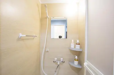 a bathroom with a shower with a mirror and a sink at \u65b0\u5bbf\u76f4\u901a \u89b3\u5149 \u30b7\u30e7\u30c3\u30d4\u30f3\u30b0 \u30b0\u30eb\u30e1\u30b9\u30c6\u30a4 EoSL in Tokyo