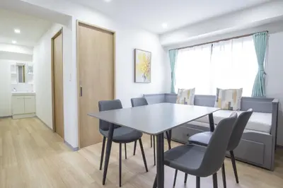 a dining room with a table and chairs at \u65b0\u5bbf\u76f4\u901a \u89b3\u5149 \u30b7\u30e7\u30c3\u30d4\u30f3\u30b0 \u30b0\u30eb\u30e1\u30b9\u30c6\u30a4 EoSL in Tokyo
