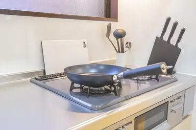 a frying pan on top of a stove in a kitchen at \u65b0\u5bbf\u76f4\u901a \u89b3\u5149 \u30b7\u30e7\u30c3\u30d4\u30f3\u30b0 \u30b0\u30eb\u30e1\u30b9\u30c6\u30a4 EoSL in Tokyo
