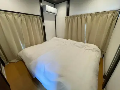 a small bedroom with a white bed and a window at \u30a2\u30f3\u30c9\u30b9\u30c6\u30a4\u65b0\u4e952\u4e01\u76ee in Tokyo