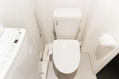 a white bathroom with a toilet and a sink at shinjuku house in Tokyo