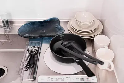 a frying pan on a plate next to a pile of dishes at shinjuku house in Tokyo