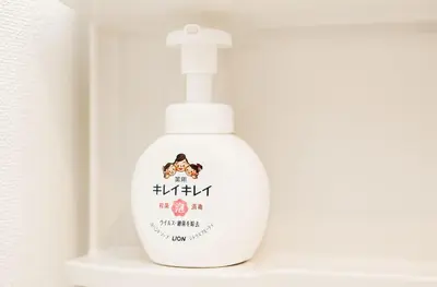 a white bottle of soap sitting on a shelf at shinjuku house in Tokyo