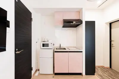 a small kitchen with a white refrigerator and a microwave at shinjuku house in Tokyo