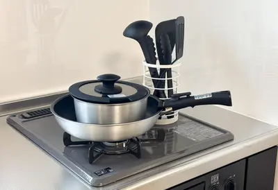 a pot on top of a stove with utensils at \u304b\u3064\u3089301 in Tokyo
