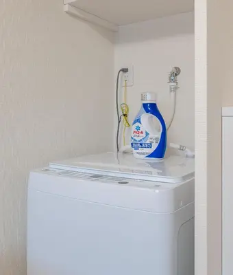 a blue bottle of cleaner sitting on top of a washer at \u304b\u3064\u3089301 in Tokyo