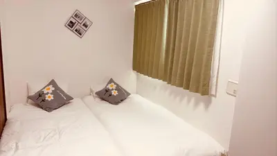 a bedroom with two twin beds with pillows at \u30b9\u30ab\u30a4\u30c4\u30ea\u30fc\u306e\u5bbf 501 in Tokyo