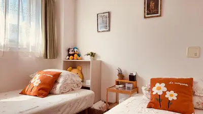 a bedroom with two beds and a window at \u30b9\u30ab\u30a4\u30c4\u30ea\u30fc\u306e\u5bbf 501 in Tokyo