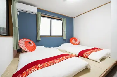 two beds in a room with blue walls and windows at \u98a8\u82b1Fuka\u6c11\u6cca\u5927\u68ee\u672c\u753a in Tokyo