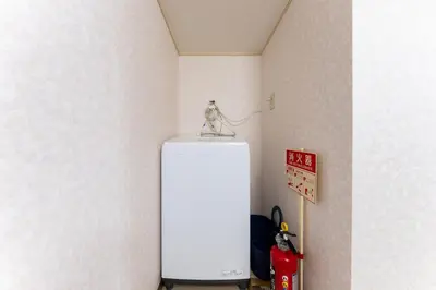 a small dog sitting on top of a refrigerator at shinjuku-ookubo Apartment room101 in Tokyo