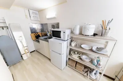 a small kitchen with a refrigerator and a microwave at shinjuku-ookubo Apartment room102 in Tokyo