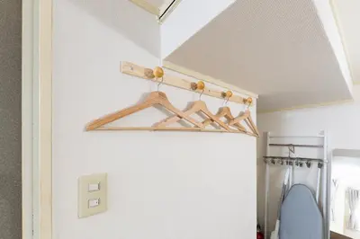 a bathroom with a closet with wooden hangers at shinjuku-ookubo Apartment room102 in Tokyo