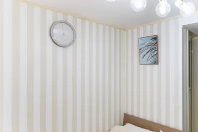a bedroom with striped walls and a clock on the wall at shinjuku-ookubo Apartment room102 in Tokyo