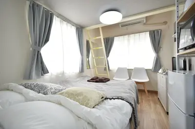 a small bedroom with two beds and a window at shinjuku-ookubo Apartment room201 in Tokyo