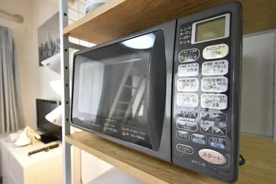 a microwave oven on a shelf in a kitchen at shinjuku-ookubo Apartment room201 in Tokyo