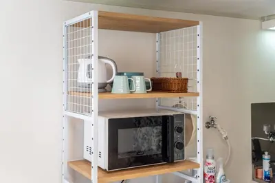 a white shelf with a microwave on top of it at shinjuku-ookubo Apartment room202 in Tokyo