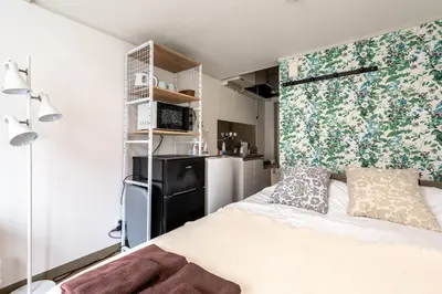 a small bedroom with a bed and a refrigerator at shinjuku-ookubo Apartment room202 in Tokyo