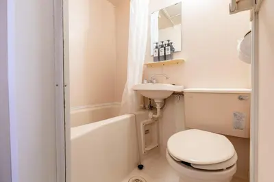 a white bathroom with a toilet and a sink at shinjuku-ookubo Apartment room202 in Tokyo