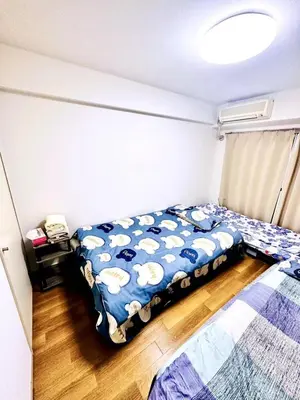a bedroom with a bed with a blue comforter at Tokyo West Shinjuku close to Shinjuku Chuo Park in Tokyo