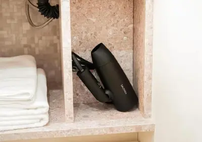 a hair dryer sitting on a shelf in a bathroom at Oshiage SAIEI Hotel 403 in Tokyo