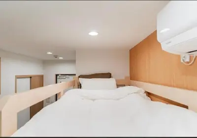 two beds in a small room with white sheets at Oshiage SAIEI Hotel 403 in Tokyo