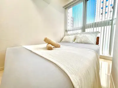 a bed with a teddy bear sitting on it in a window at Shinjuku City Apt, 2DB , Free WiFi in Tokyo