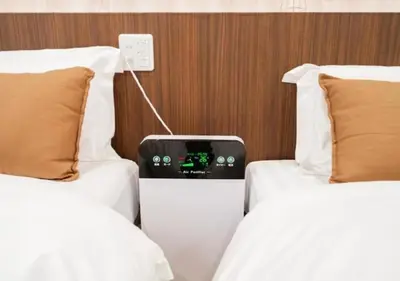 a room with two beds and a clock between them at Oshiage SAIEI Hotel 402 in Tokyo