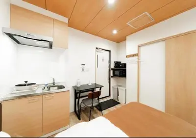 a kitchen with a sink and a table in a room at Oshiage SAIEI Hotel 402 in Tokyo